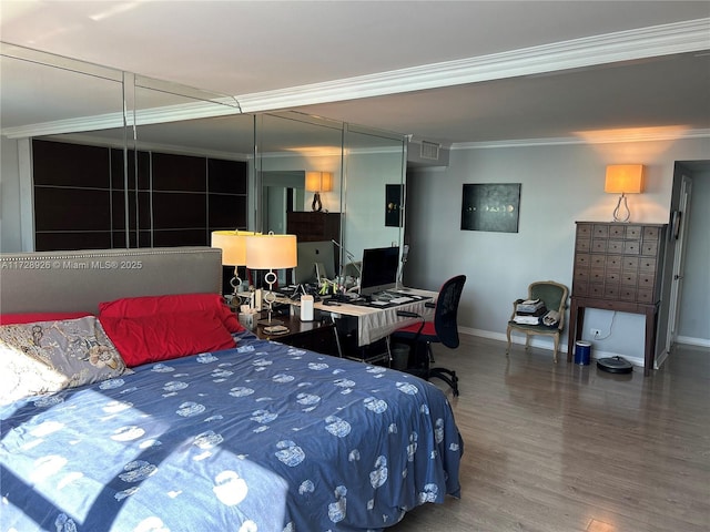 bedroom with ornamental molding and hardwood / wood-style floors