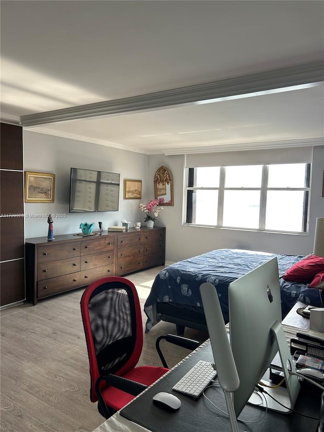 bedroom with ornamental molding and light hardwood / wood-style flooring