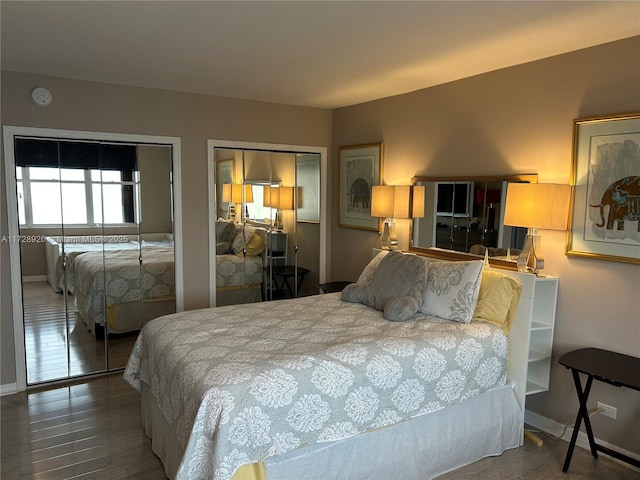 bedroom with multiple closets and wood-type flooring