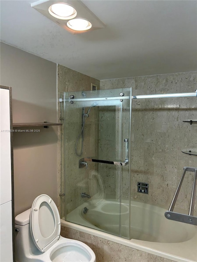 bathroom with bath / shower combo with glass door and toilet