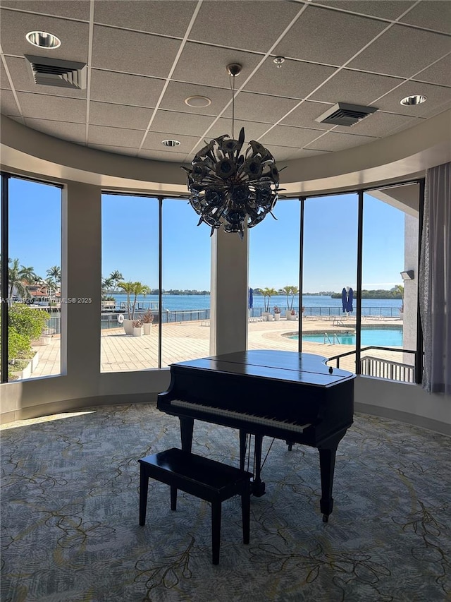 misc room with a drop ceiling and a water view