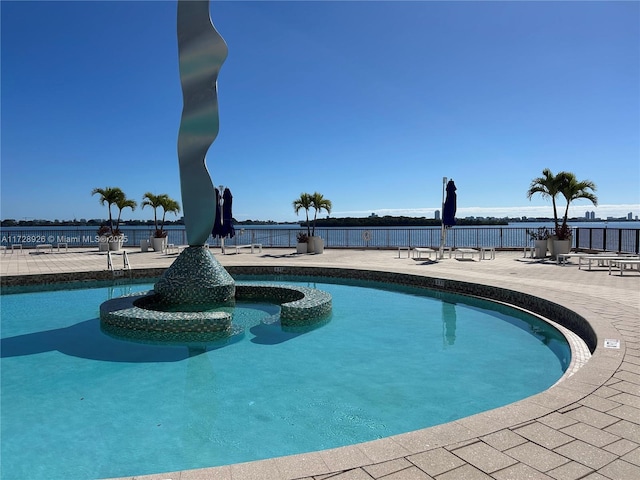 view of pool featuring a water view and a patio area