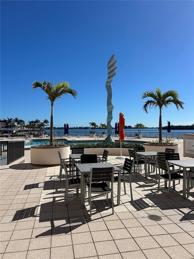 view of patio featuring a community pool and a water view