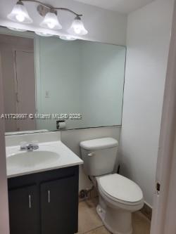 bathroom with toilet, tile patterned flooring, and vanity