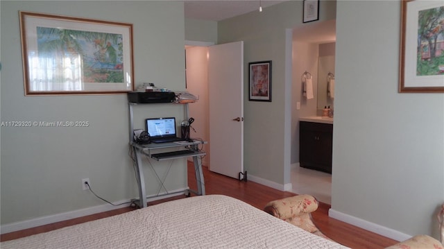 bedroom featuring light hardwood / wood-style floors and ensuite bath