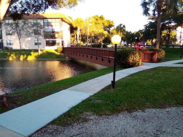 view of community featuring a water view and a yard