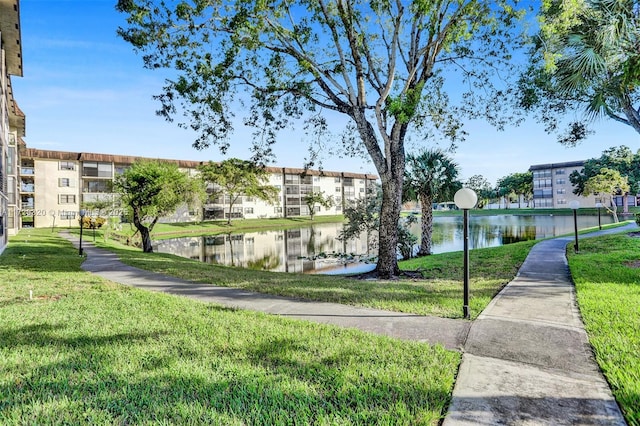 view of home's community with a lawn and a water view