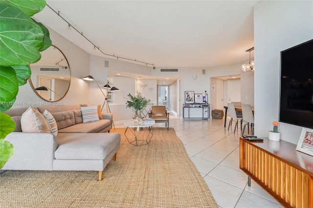 living area with light tile patterned floors, rail lighting, and visible vents