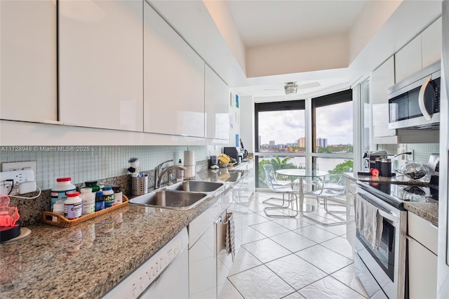 kitchen featuring a sink, white cabinetry, appliances with stainless steel finishes, backsplash, and modern cabinets