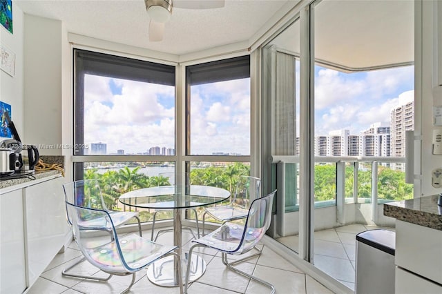 sunroom featuring ceiling fan and a view of city