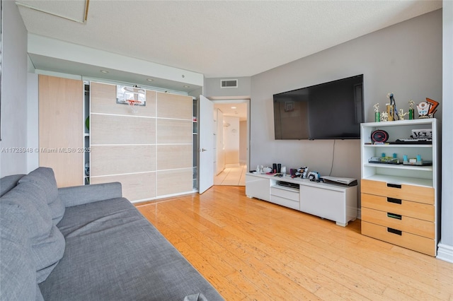 living room featuring light wood-style flooring and visible vents