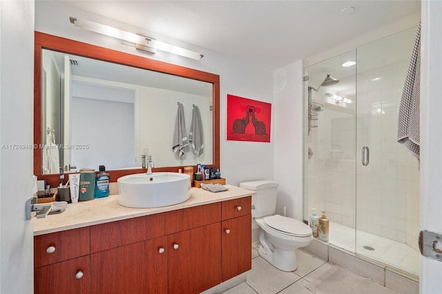 bathroom featuring toilet, a stall shower, tile patterned flooring, and vanity