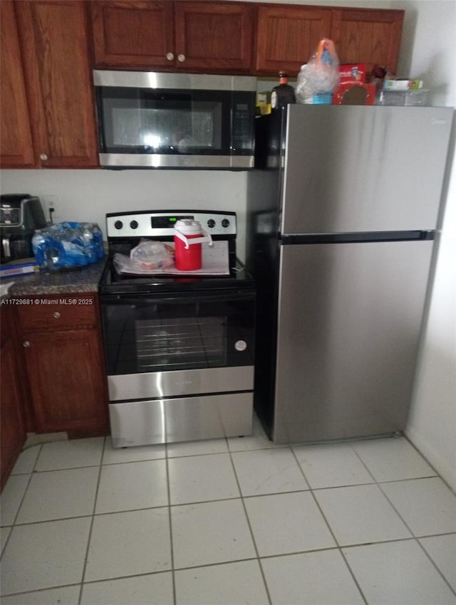 kitchen with light tile patterned flooring and appliances with stainless steel finishes