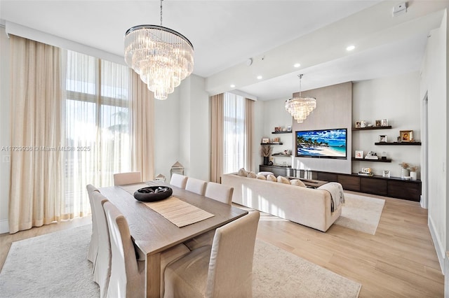 dining space with light hardwood / wood-style flooring and a notable chandelier