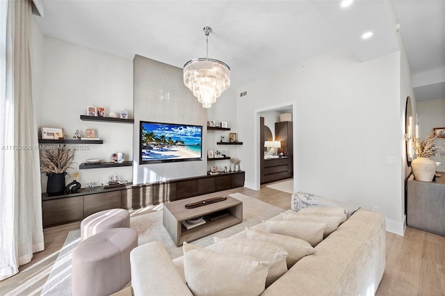 living room with light wood-type flooring and an inviting chandelier