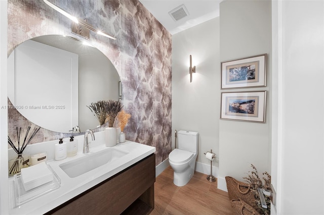 bathroom with wood-type flooring, toilet, and vanity