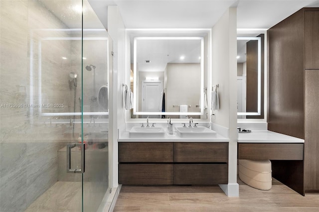 bathroom featuring hardwood / wood-style flooring, walk in shower, and vanity