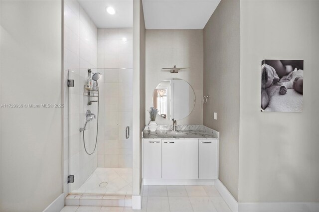 bathroom featuring tile patterned floors, a shower with door, and vanity