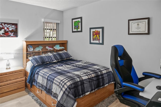 bedroom with light hardwood / wood-style flooring and a textured ceiling