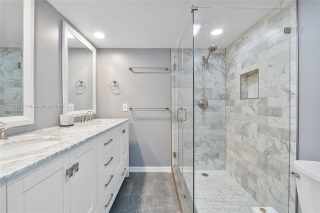 bathroom featuring toilet, a shower with door, and vanity