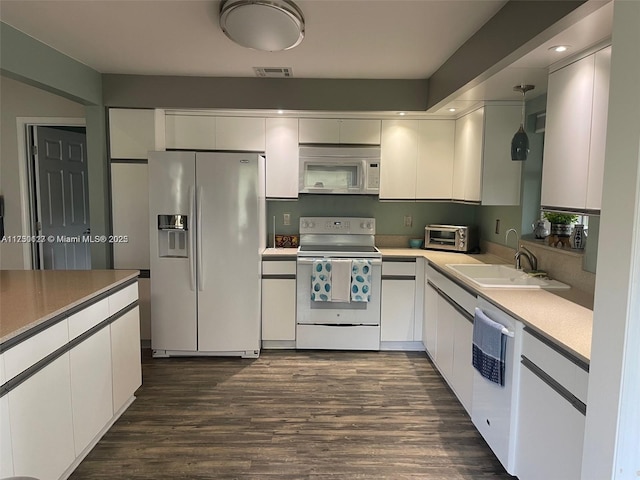 kitchen with decorative light fixtures, sink, white appliances, and white cabinets