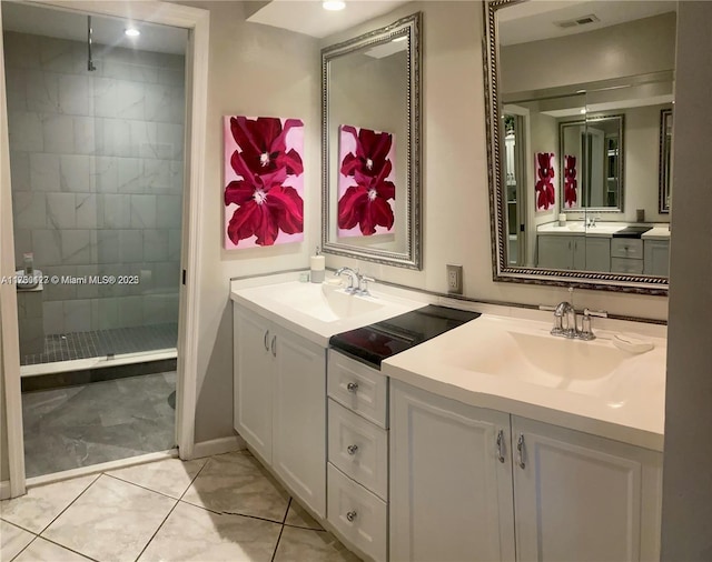 bathroom featuring vanity, tile patterned floors, and tiled shower