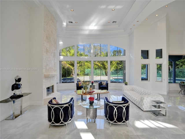 living room featuring a fireplace, ornamental molding, and a high ceiling