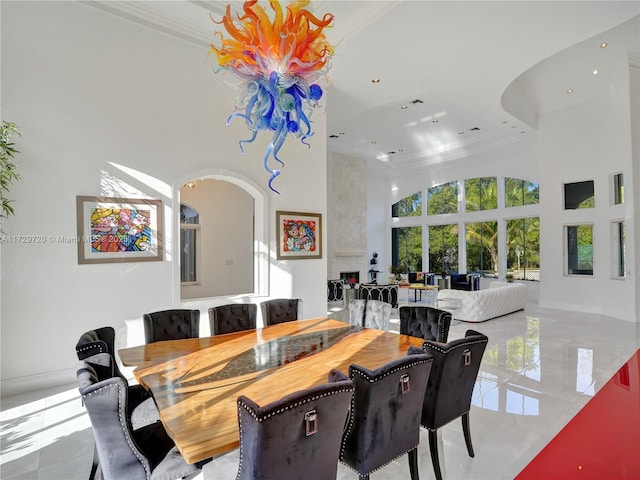 dining area featuring crown molding and a towering ceiling