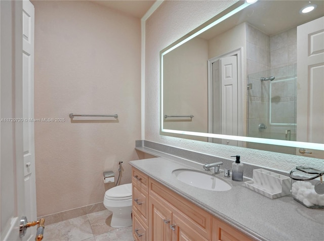 bathroom with tile patterned floors, vanity, toilet, and a shower with door