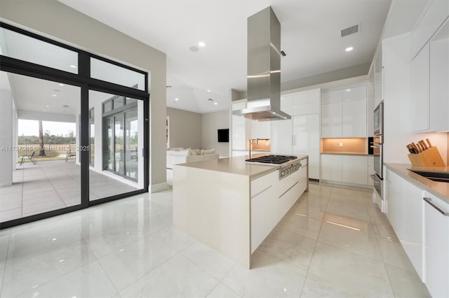 kitchen featuring white cabinetry, a center island, island exhaust hood, and stainless steel appliances