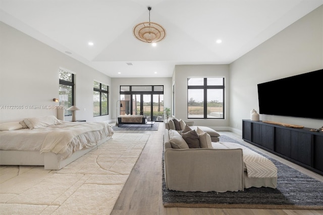 bedroom with vaulted ceiling and light hardwood / wood-style flooring