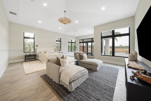 bedroom with a towering ceiling and light hardwood / wood-style flooring