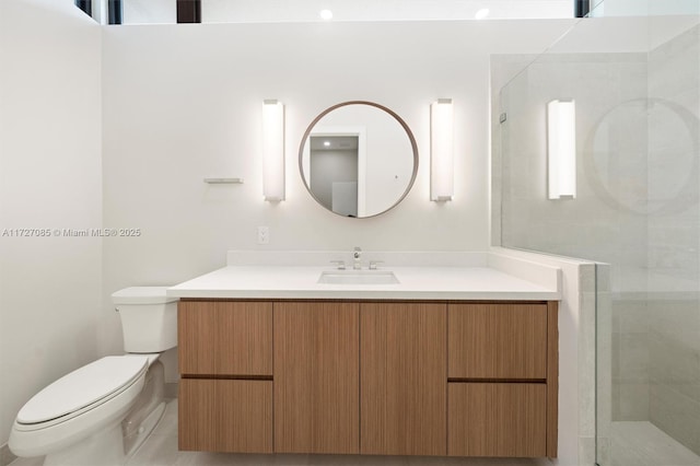 bathroom featuring a shower with door, toilet, and vanity