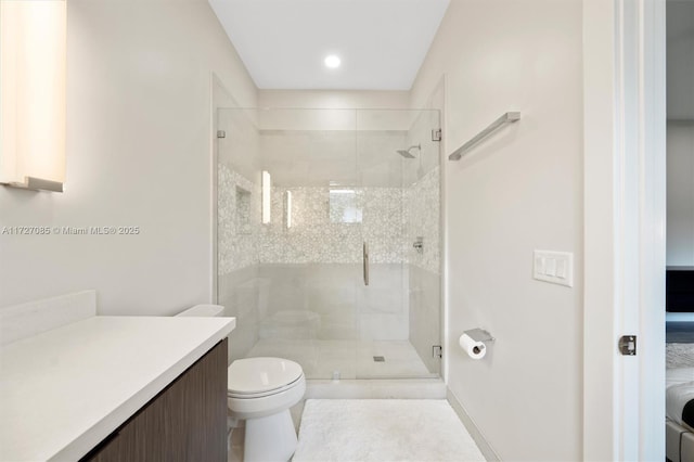 bathroom with tile patterned floors, toilet, a shower with door, and vanity