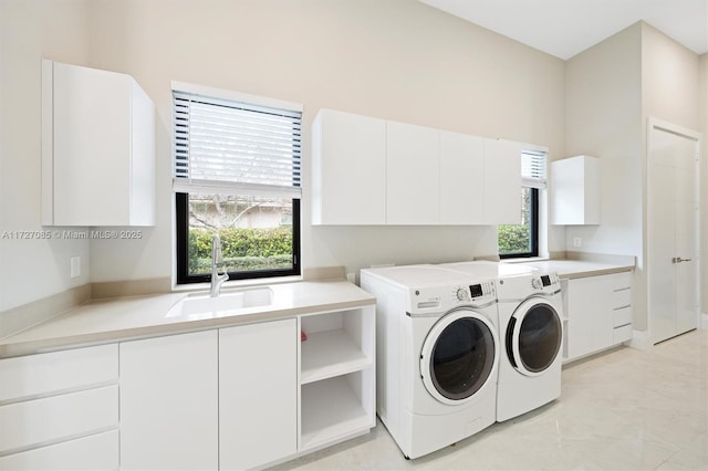 laundry room featuring washer and dryer, cabinets, a wealth of natural light, and sink