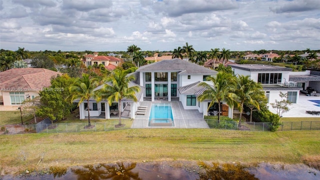 back of property featuring a fenced in pool, a patio area, and a yard