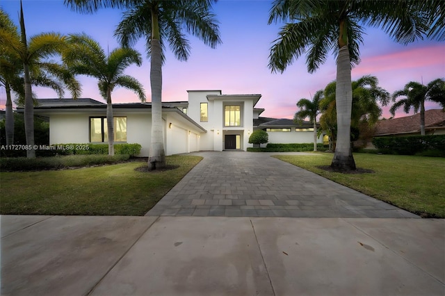 view of front facade with a yard and a garage