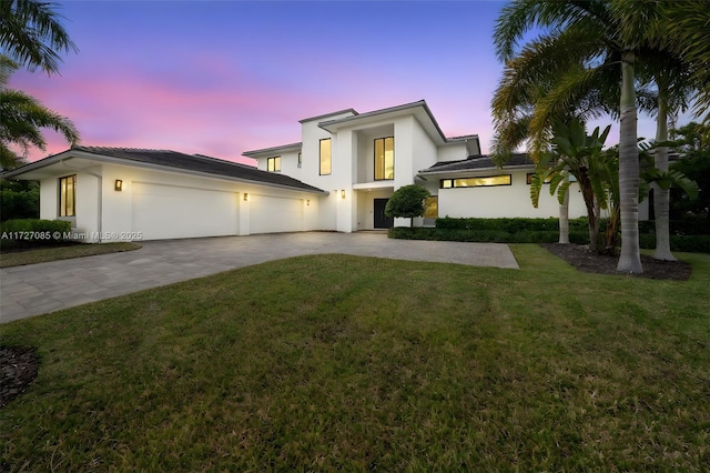 view of front of house with a garage and a yard