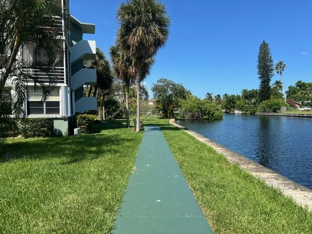 view of home's community featuring a lawn and a water view