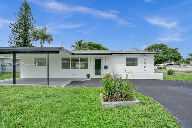 view of front of house with a front yard and a carport