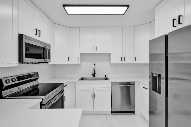 kitchen with stainless steel appliances, white cabinetry, and sink