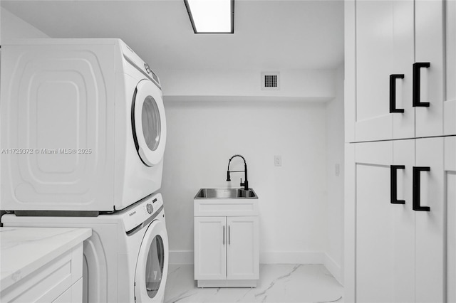 washroom with stacked washer / dryer, sink, and cabinets