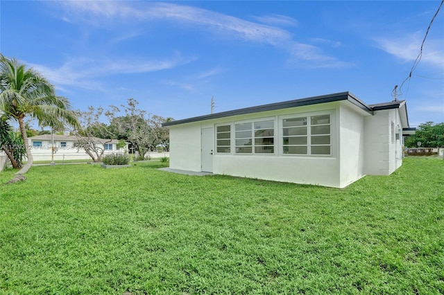 rear view of property with a lawn