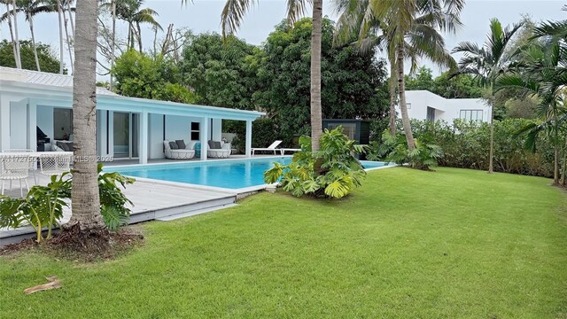 view of pool with a wooden deck and a yard