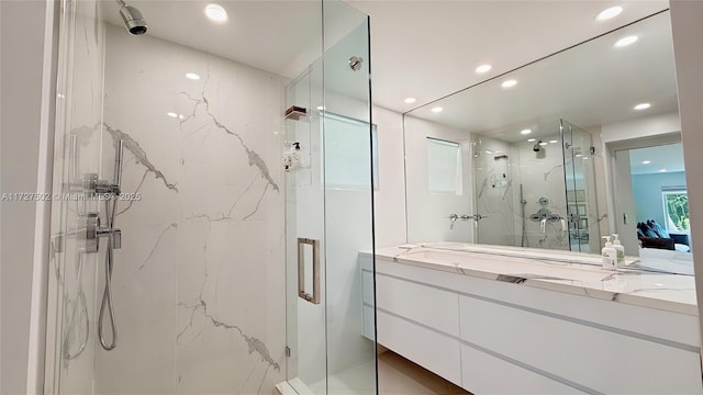 bathroom with a shower with shower door and vanity