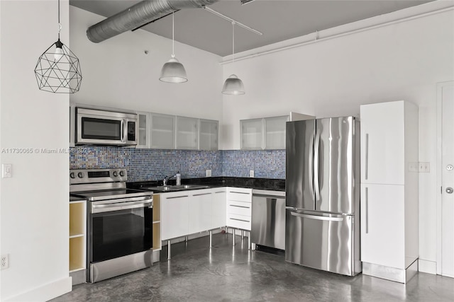 kitchen with white cabinets, appliances with stainless steel finishes, decorative light fixtures, decorative backsplash, and sink