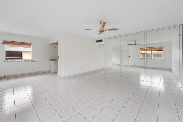 unfurnished room with light tile patterned floors, ceiling fan, visible vents, and baseboards