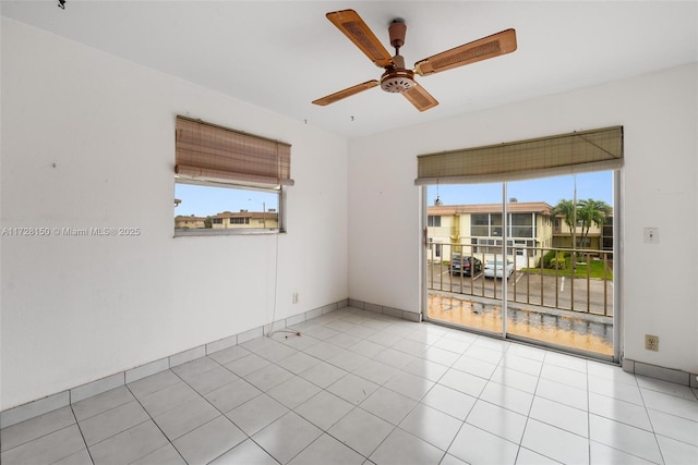 unfurnished room with light tile patterned floors, ceiling fan, and baseboards