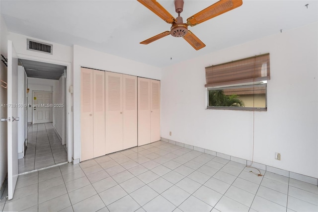 unfurnished bedroom with a ceiling fan, a closet, visible vents, and light tile patterned floors