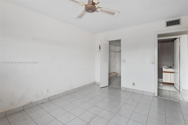 unfurnished bedroom featuring light tile patterned floors, a closet, visible vents, and a ceiling fan